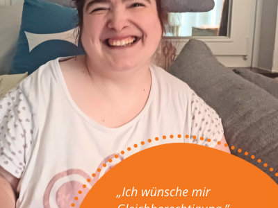 Eine Person mit einem hellen T-Shirt und dunklen Haaren sitzt auf einem Sofa und lächelt in die Kamera. In einer orangenen Textblase mit orangenen Punkten drum herum steht folgender Text: „Ich wünsche mir Gleichberechtigung. Frau Kaminska“